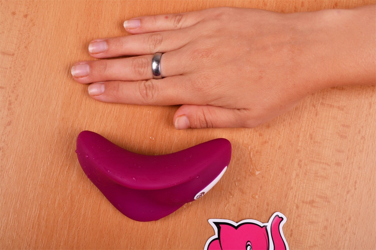 Small purple Dragonfly leží na stole vedle dlaně